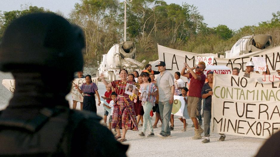 Eine Gruppe von Demonstrant*innen geht mit Schildern auf die Straße. 